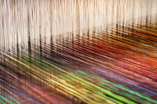 Close-up of a loom weaving colorful fabric (XXXL)