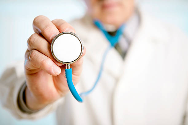 Close-up of a male doctor hand holding a stethoscope stock photo