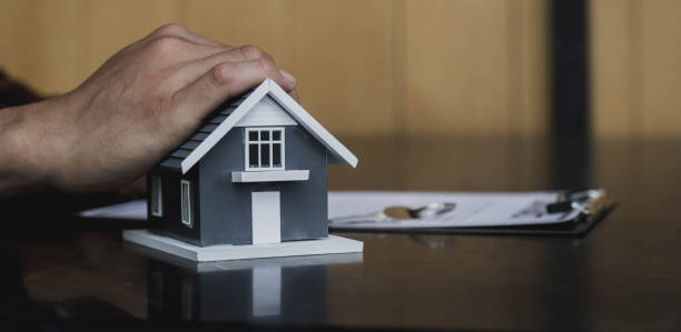 Close-up of a man holding a small house. Concept of purchasing new apartment. stock photo