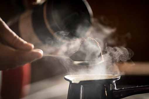 Close-up of a Man Preparing Coffee in Coffee Pot on Stove.