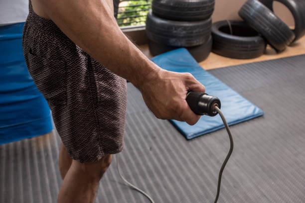 Closeup of a man's hand grasping a jumping rope ready to exercise at a gym or fitness center. stock photo