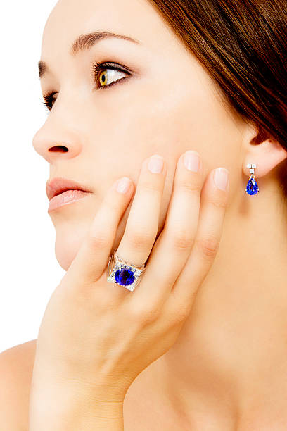 Closeup of a Model Wearing a Tanzanite Designer Ring and Earring Closeup of a Model Wearing a Tanzanite Designer Ring and Earring, Isolated on White zoisite photos stock pictures, royalty-free photos & images