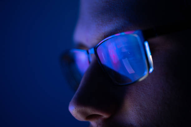 Close-up of a part of a male human face with glasses in neon light Close-up of a part of a male human face with eyeglasses in neon glow on a background of the vibrant colored liquid eyeglasses stock pictures, royalty-free photos & images
