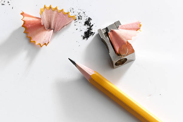 close-up of a pencil and a sharpener with pencil shavings - scherp stockfoto's en -beelden