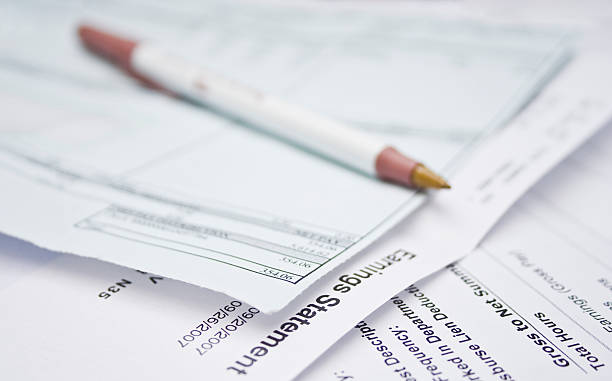 Close-up of a pile of bills with pen on top stock photo