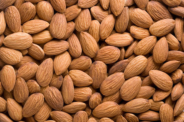 A closeup of a pile of raw almonds stock photo