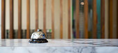 istock Closeup of a silver service bell on hotel reception desk. 1312916120