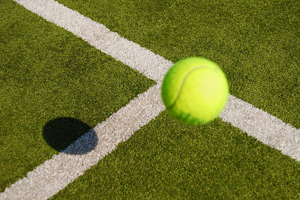 Closeup of a tennis ball about to land on the ground stock photo
