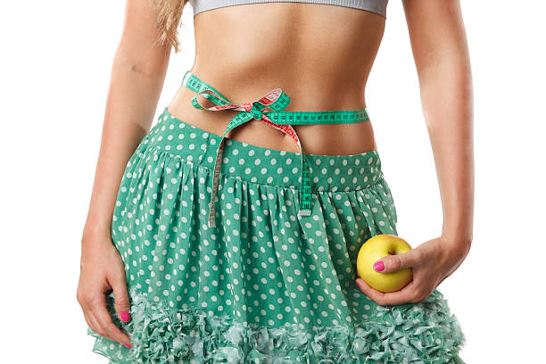 Closeup of a woman stomach with a measuring-tape stock photo