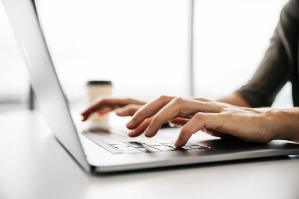 Close-up of a woman working on a laptop stock photo