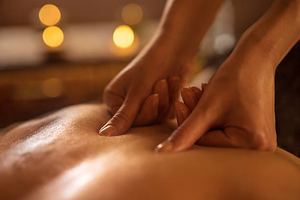 Close-up of alternative therapy at the spa. Close-up of massage therapist applying pressure on man's back at the spa. massaging photos stock pictures, royalty-free photos & images