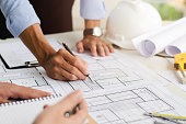 istock Close-up of an engineer planning a hand-drawn design. with architect equipment Architects talking at the table Teamwork and workflow concepts 1358582944