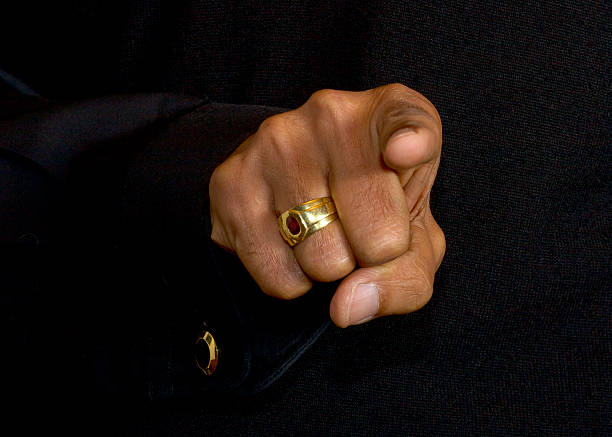 Close-up Of Asian Indian Male Hand Against Black Background - Gesture ‘You’ Pointing Directly Into Camera Lens. Studio Shot. An older Indian male uses a hand gesture to point and say, "You".  It could be an accusation, or a selection of a person, or just a simple YOU. gold ring on finger stock pictures, royalty-free photos & images
