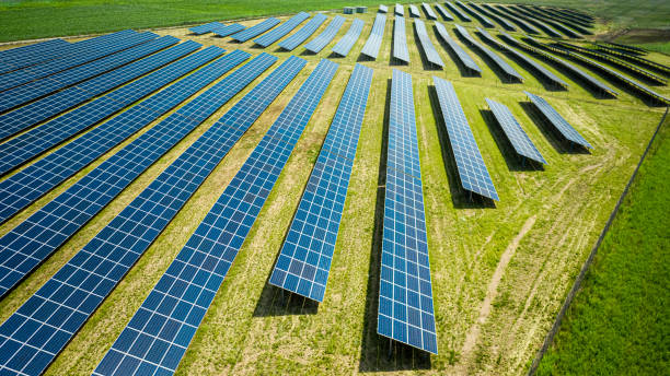 Closeup of blue solar panels on green field, aerial view stock photo