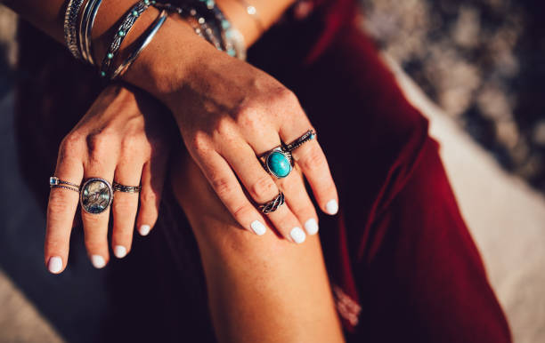 Close-up of young woman's hands with freckles and boho style rings and bracelets