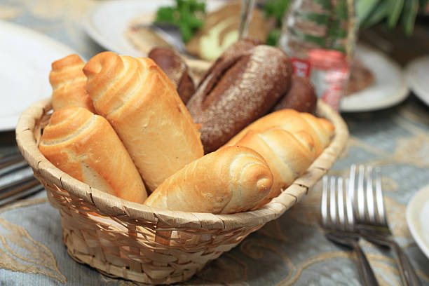Closeup of bread rolls in basket on restaurant table stock photo