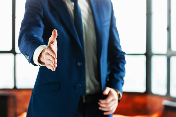 Close-up of business man with hand extended to handshake. stock photo
