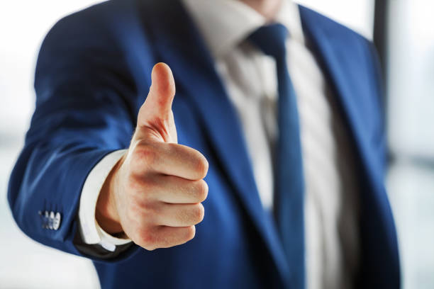 Closeup of business person showing thumb up. stock photo