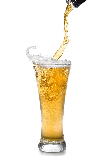 Close-up of clear beer pouring from bottle into a glass stock photo