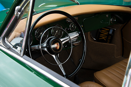 Anaheim, CA, USA - March 3, 2013: A look through the window of a vintage green Porsche 356, with a view of the steering wheel, dashboard, gauges, and restored beige upholstery at the 4th Annual Southern California All Porsche Swap and Car Display, which took place at The Phoenix Club.