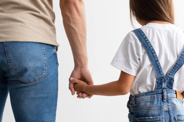 Closeup of father and daughter holding hands Trust And Support Concept. Cropped close up of man and girl holding hands, enjoying spending free time together, isolated over white studio background. Love And Family Care cute arab girls stock pictures, royalty-free photos & images