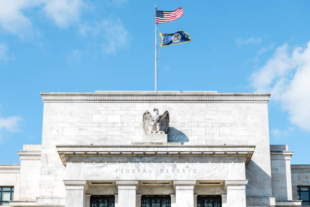 Closeup of Federal Reserve bank facade entrance, architecture building, eagle statue American flags, blue sky at sunny day stock photo