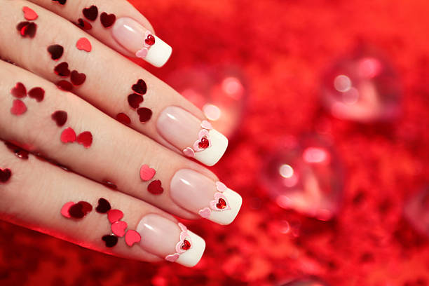Close-up of French manicured nails and tiny ready hearts stock photo
