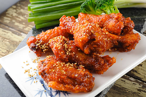 Close-up of fried chicken wings sprinkled with sesame Fried Chicken in Asian Style korean culture photos stock pictures, royalty-free photos & images