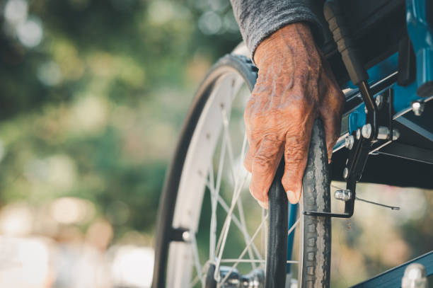 close-up  of hand senior man pushing wheelchair stock photo