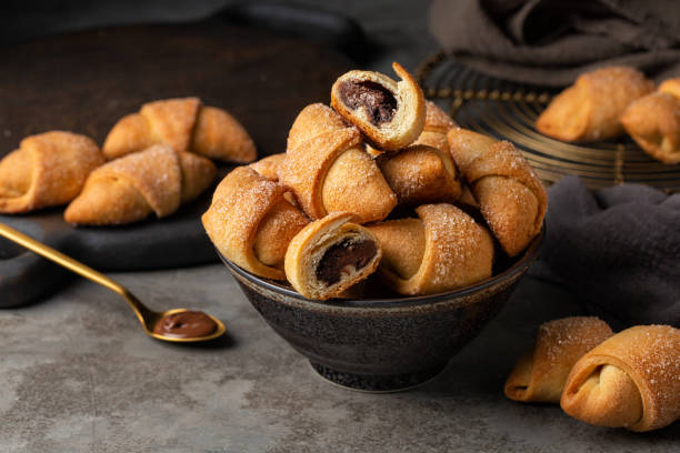 Close-up of homemade filled pastries - rugelach or kipferl. Made with butter and cream cheese doughs with hazelnut chocolate cream. stock photo