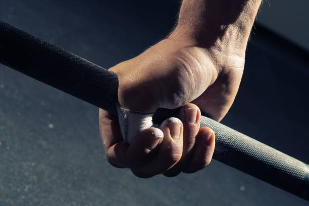 Closeup of man's hand gripping a barbell stock photo