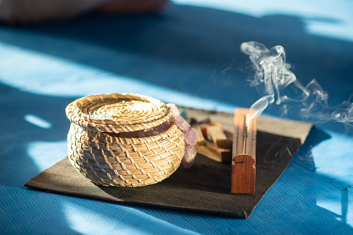 Close-up of meditation tools in room. Basket, colorful stones and other religious ritual instruments for meditation. Spirituality, health concept