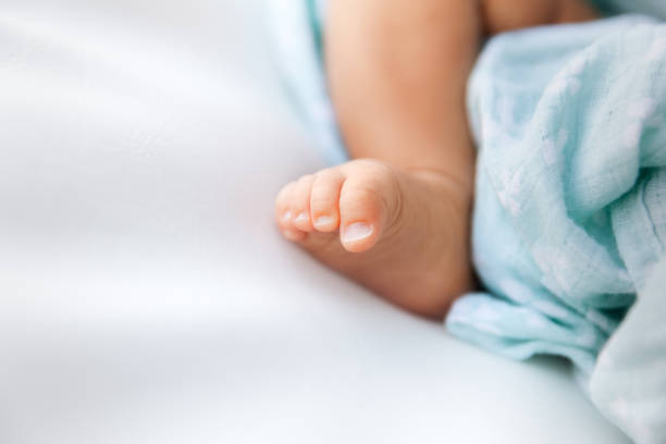 Closeup of newborn foot and toes on a white background with copyspace on the left stock photo