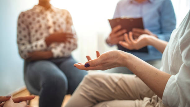 Close-up of people communicating while sitting in circle and gesturing. Close-up on discussion. Close-up of people communicating while sitting in circle and gesturing. Close-up of therapist's hands explaining a problem to his patients. People participating in group therapy group therapy stock pictures, royalty-free photos & images