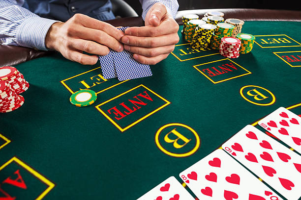Closeup of poker player with playing cards and chips Close up of poker player with playing cards and chips at green casino table. texas shooting stock pictures, royalty-free photos & images