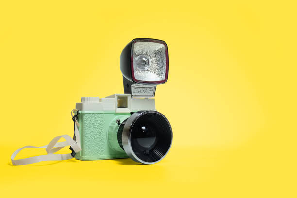 primer plano de la cámara retro con flash contra fondo amarillo - camera flash fotografías e imágenes de stock