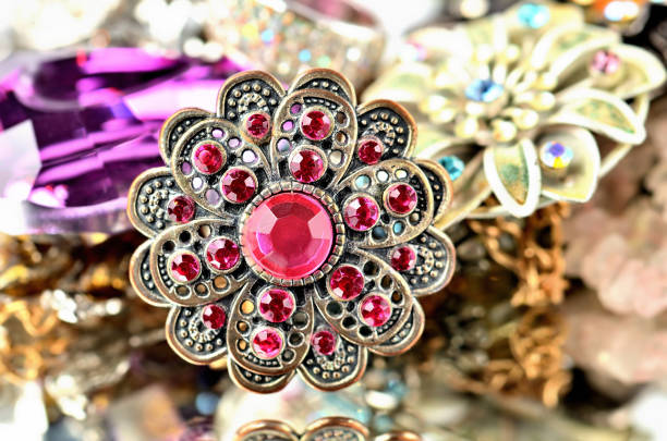 Close-up of richly decorated brooch - red artificial stones stock photo