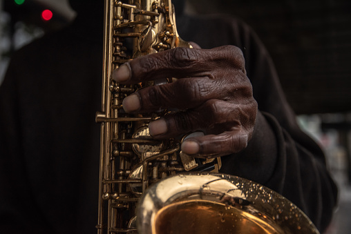 A close-up of a street performer in New Orleans playing the saxophone.