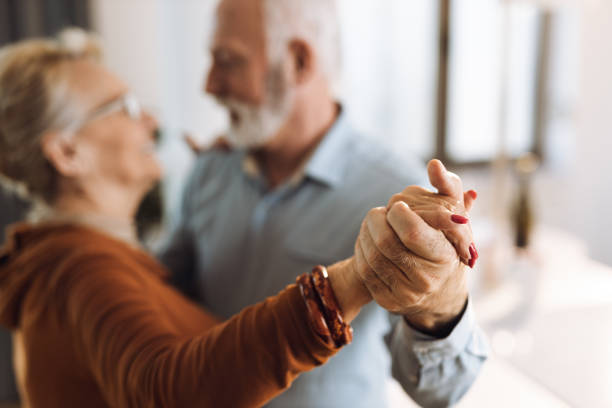 Close-up  of senior couple holding hands while dancing stock photo