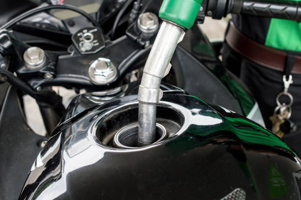 Close-up of someone refilling gas to the motorcycle barrel tank in gas petrol station. stock photo