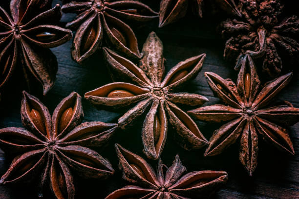 Close-up of star anise on wooden old fashioned table Close-up of star anise on wooden old fashioned table anise stock pictures, royalty-free photos & images