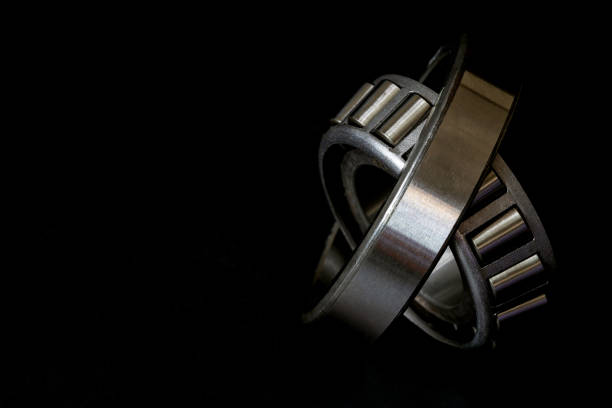 Closeup of Tapered roller bearing on black background, Spare part of mechanical industry. stock photo