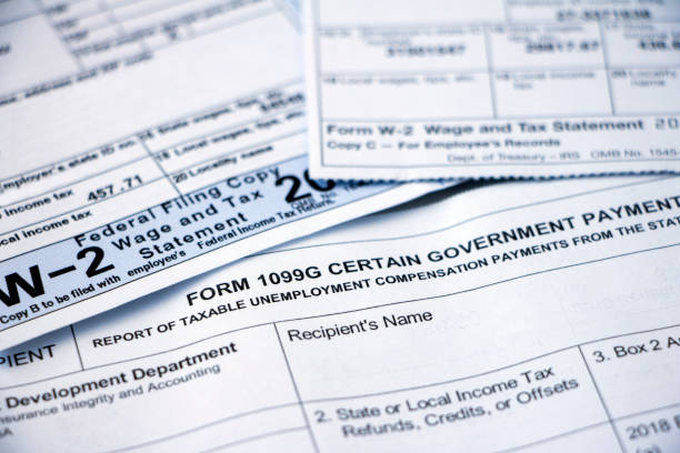 Closeup of tax forms, 1099G and W-2 Closeup of overlapping Form 1099G Certain Government Payouts and W-2 forms. irs stock pictures, royalty-free photos & images