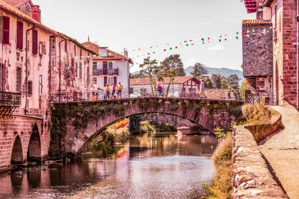 Close-up of the bridge over the river Nive on its way through the village of Saint Jean Pied de Port and in the background the Pyrenees. France. stock photo