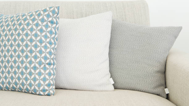 Close-up of three different sizes cushions in soft, pastel colors stock photo