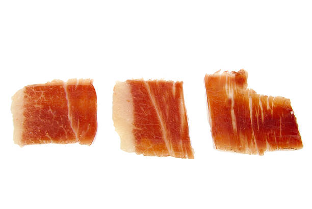 Closeup of three serrano ham slices isolated on white background Closeup of three serrano ham slices isolated on white background. Jabugo. Spanish tapa animal leg stock pictures, royalty-free photos & images