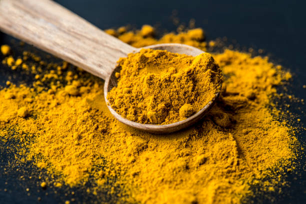 Closeup of tumeric powder spice on a spoon Closeup of tumeric powder spice on a spoon cumin stock pictures, royalty-free photos & images