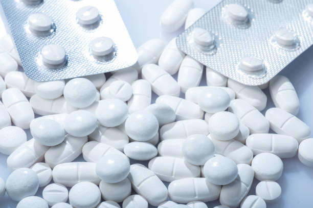 Closeup of white pills in blister packaging against white background. stock photo