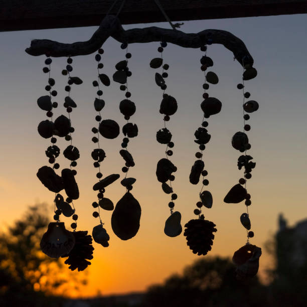 日没前に木、貝殻、ビーズで作られた風鈴のクローズアップ - 風鈴 ストックフォトと  画像