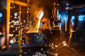 istock Close-up of work with liquid hot metal in foundry 1335706402